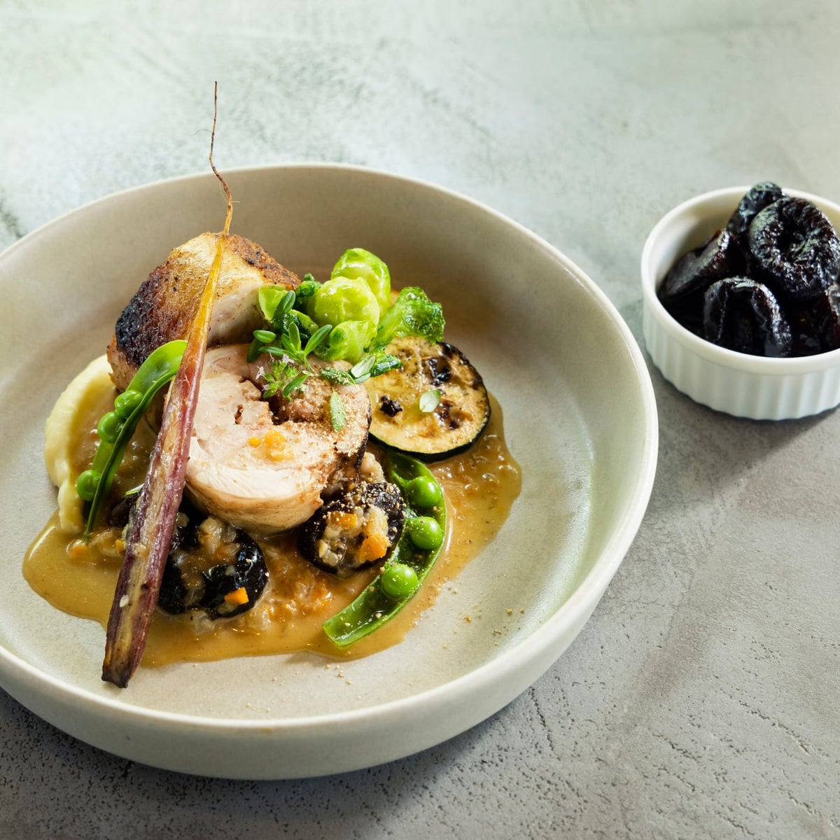 Ballotine of minced chicken and prune puree wrapped in chicken thigh, served with a sauce made by simmering prunes in chicken broth, butter, and white wine.