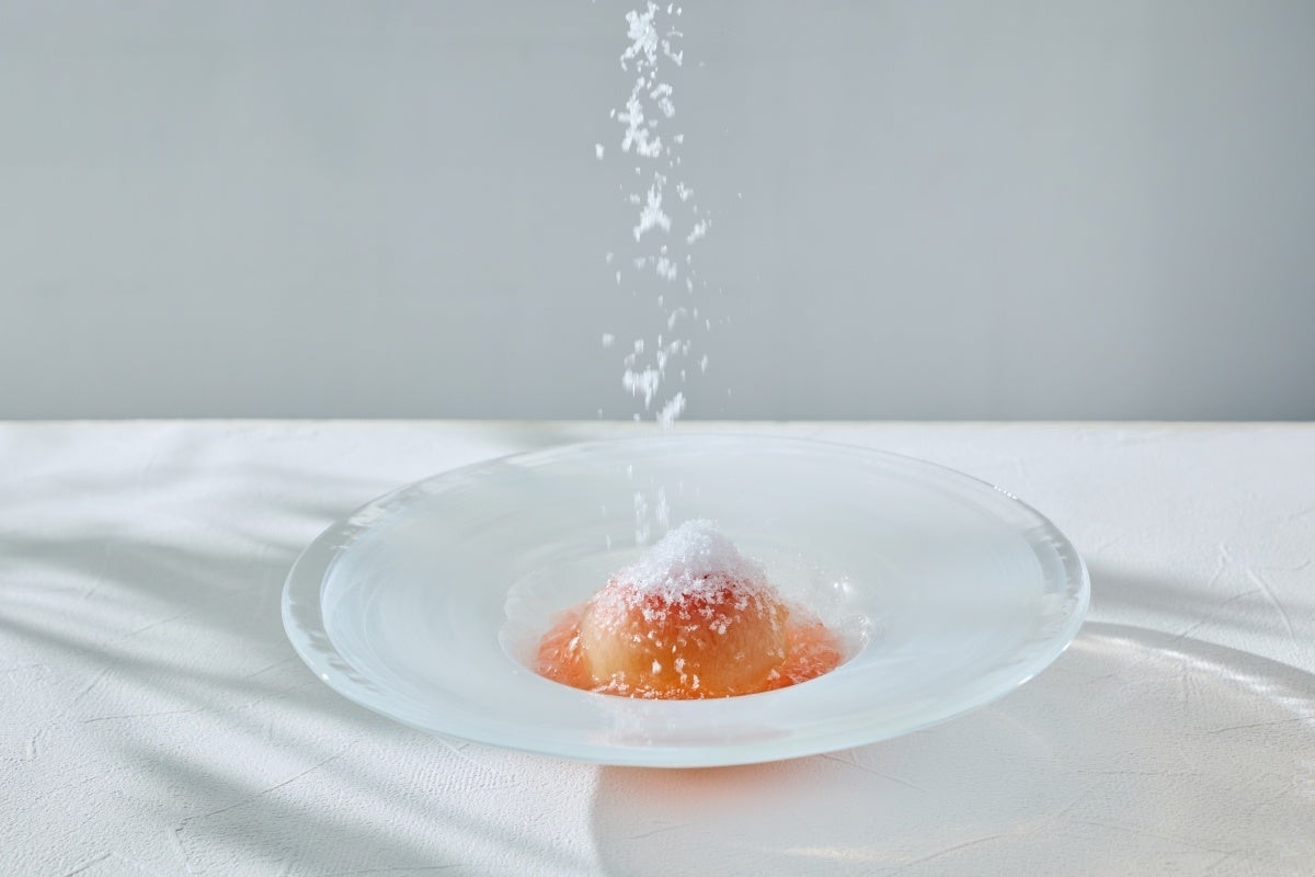Falling ice gently envelops the white peach, creating a visually refreshing moment