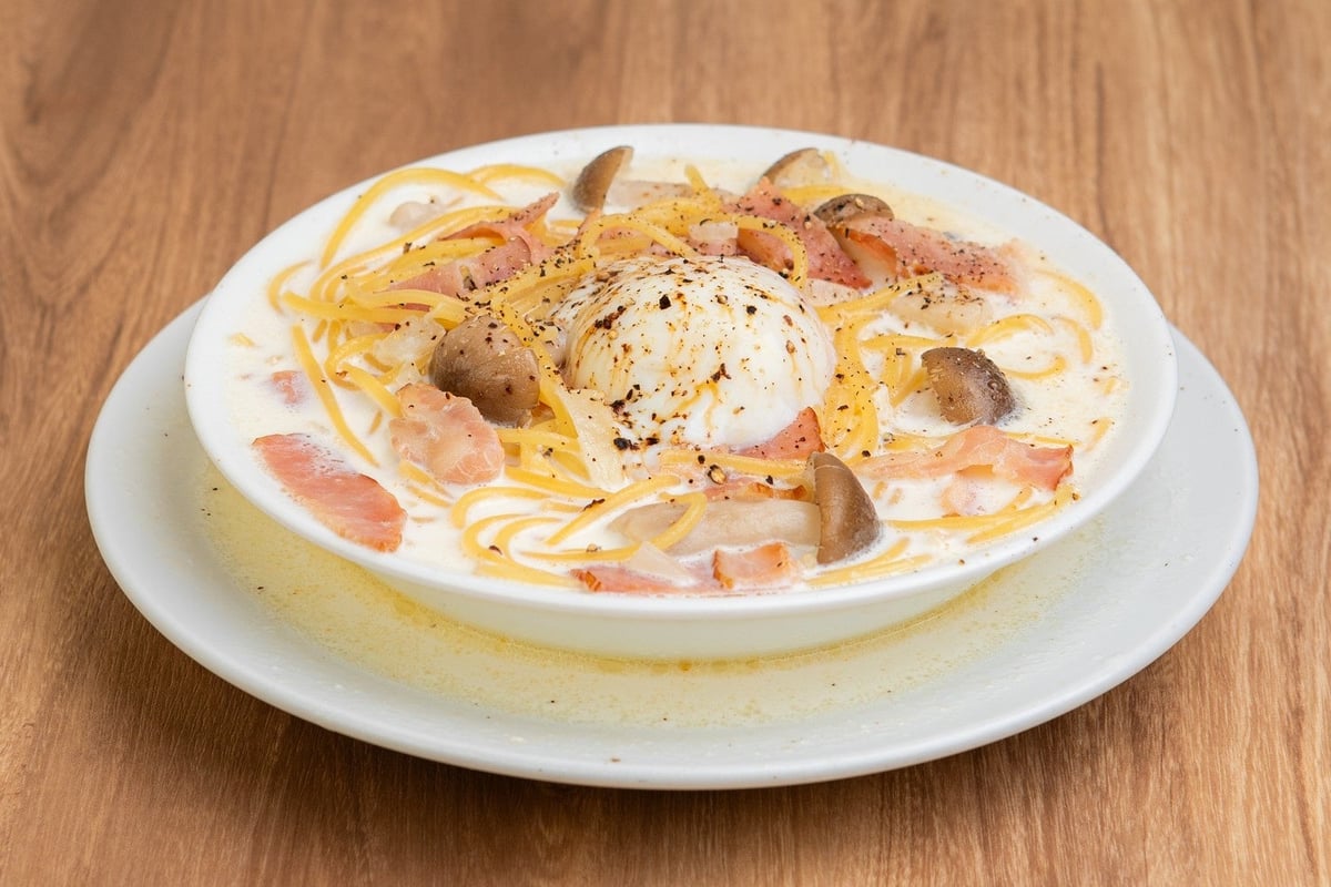 A carbonara with the rich sauce of three kinds of mushrooms and Parmesan cheese, topped with a soft-boiled egg for extra richness.