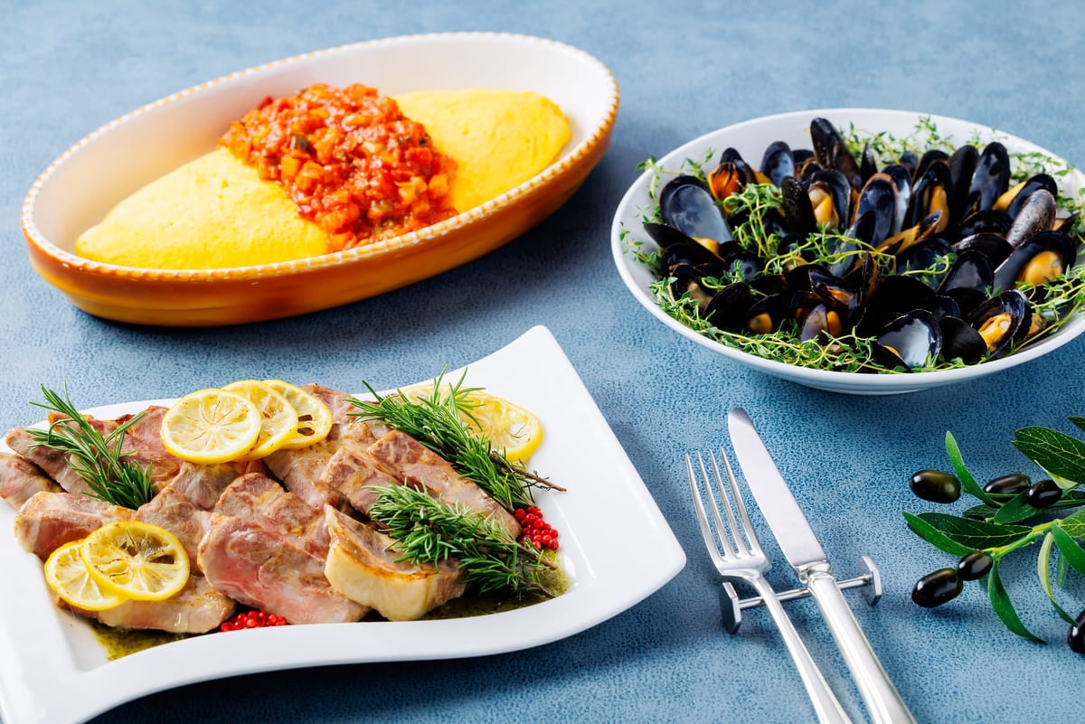 Oven-roasted pork marinated in lemon with Salmorejo sauce (front), jumbo omelette with ratatouille sauce (left back), mussels steamed in white wine fisherman's style (right back)
