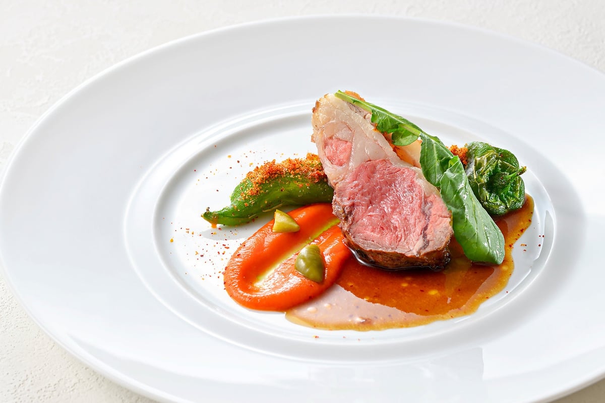 A dish from the lunch course 'Menu Dejeuner': Roast lamb loin with spice flavor, served with black olive jus and aji amarillo pepper coulis. Available from July 7 (Tue) to September 7 (Mon).