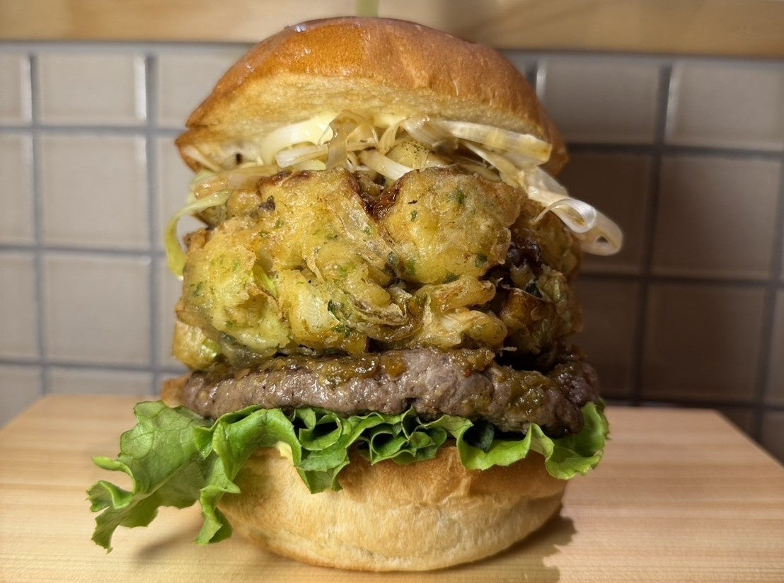 We have launched the Edosenju Negi Kakiage BIG Burger, approximately 15cm tall, priced at ¥1,980 (tax included). We hope many people will enjoy it. Additionally, our menu features a variety of craft burgers starting from ¥1,200, including the popular Edosenju Negi Burger at ¥1,380 and the Bacon Cheese Burger at ¥1,380. Our bright, park-inspired interior makes it an easy place to visit.