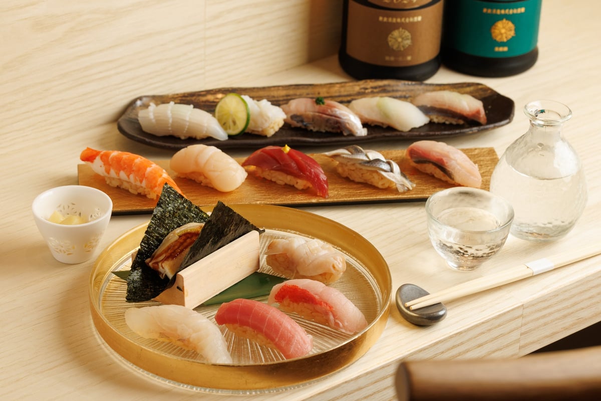 The image shows a selection of sushi with prices starting at ¥80 per piece (tax included).