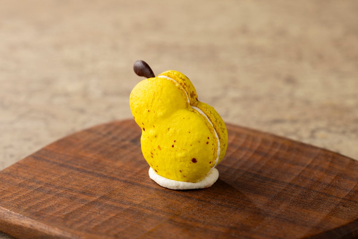 Try our pear-shaped macaron filled with buttercream and pear jam, topped with a dark chocolate stick for a charming finish.