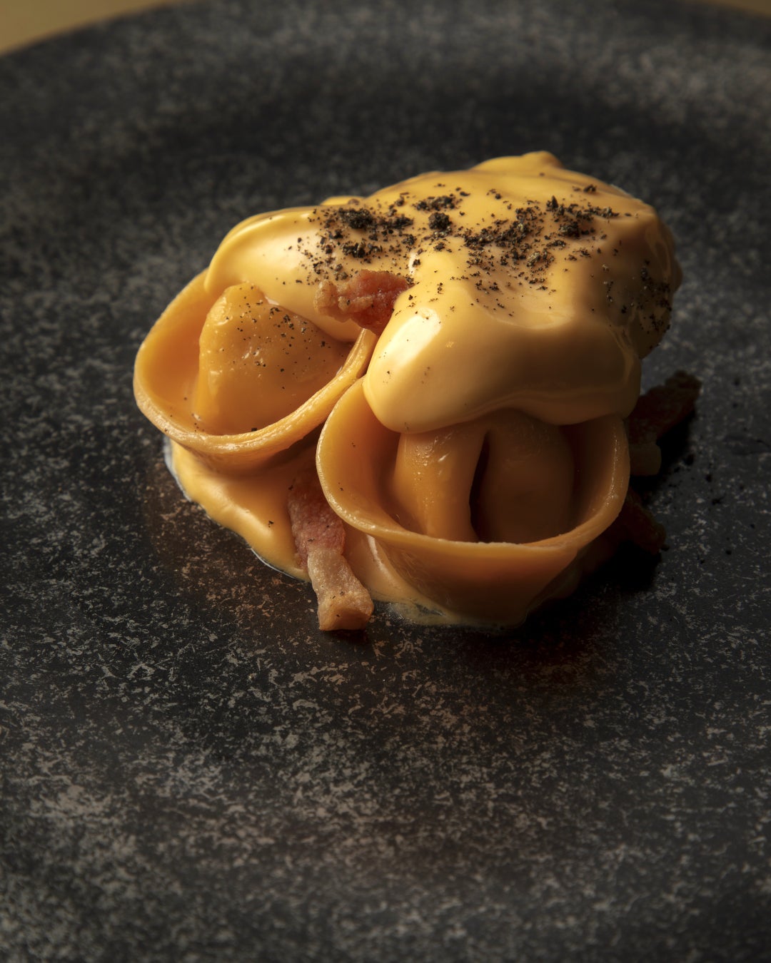 Ravioli carbonara made with Kyoto's Guanciale and eggs from Kyoto, showcasing local ingredients.
