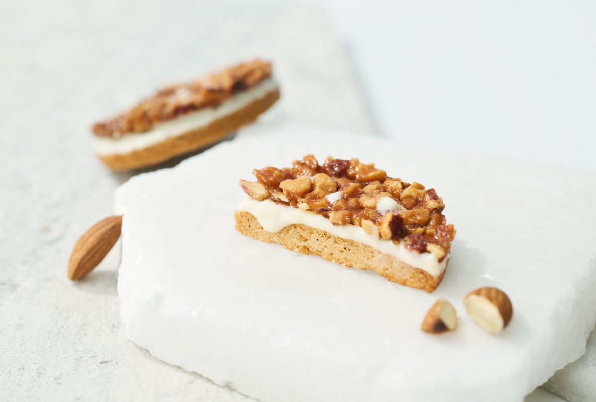 Layer 1: A luxurious layer of large skin-on almonds on a crispy tuile, baked to a fragrant finish, delivering a rich nutty sweetness and crunch. Layer 2: Smooth white chocolate with a gentle sweetness, enveloping the almonds and streusel flavors with elegance. Layer 3: Vanilla streusel with a subtle saltiness, baked to a crispy, crumbly texture with vanilla beans, accentuating the refined sweetness and aroma.