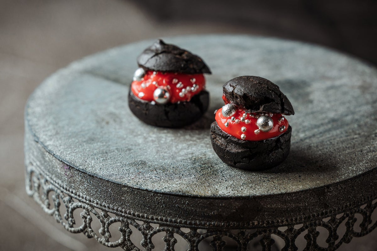 <Dark Rouge Choux> Black choux pastry filled with vivid red cream and sprinkled with silver dragées. The bold contrast of red and black makes this Halloween limited choux a striking treat.” class=”wp-image-41254″>
<figcaption class=