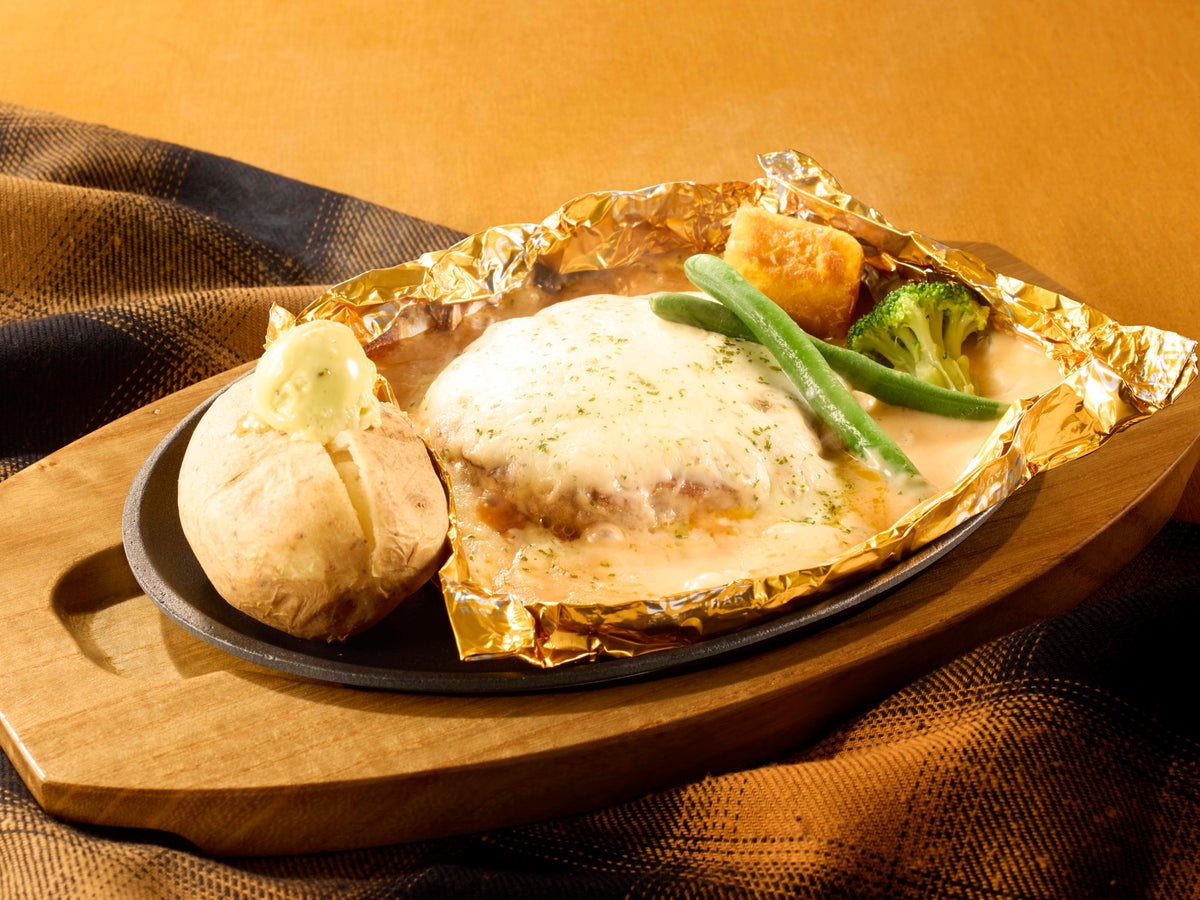 Introducing a new hamburger menu! The 7-Types Cheese Fondue Style Wrap Hamburger (145g) is priced at ¥1,290 (tax included ¥1,419). The menu features a hearty cheese sauce made with seven kinds of cheese—Stilton, Cheddar, Red Cheddar, Gouda, Blue Cheese, Mozzarella, and Parmesan—allowing you to enjoy a rich cheese flavor. It is complemented by a garlic-infused tomato sauce that adds a touch of acidity and punch. You can enjoy the hamburger, ingredients, and baked potatoes generously coated with the cheese sauce. The 110g version is available for ¥1,190 (tax included ¥1,309).