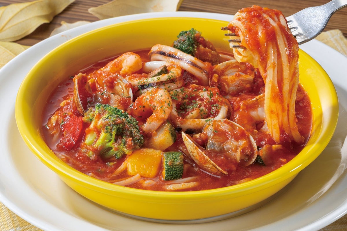 Enjoy our hearty seafood tomato soup pasta for ¥1,099 (tax included). It is generously topped with clams, shrimp, squid, and colorful vegetables. For an extra ¥100 (tax included ¥110), add a half French bread to savor every last drop of the flavorful broth.