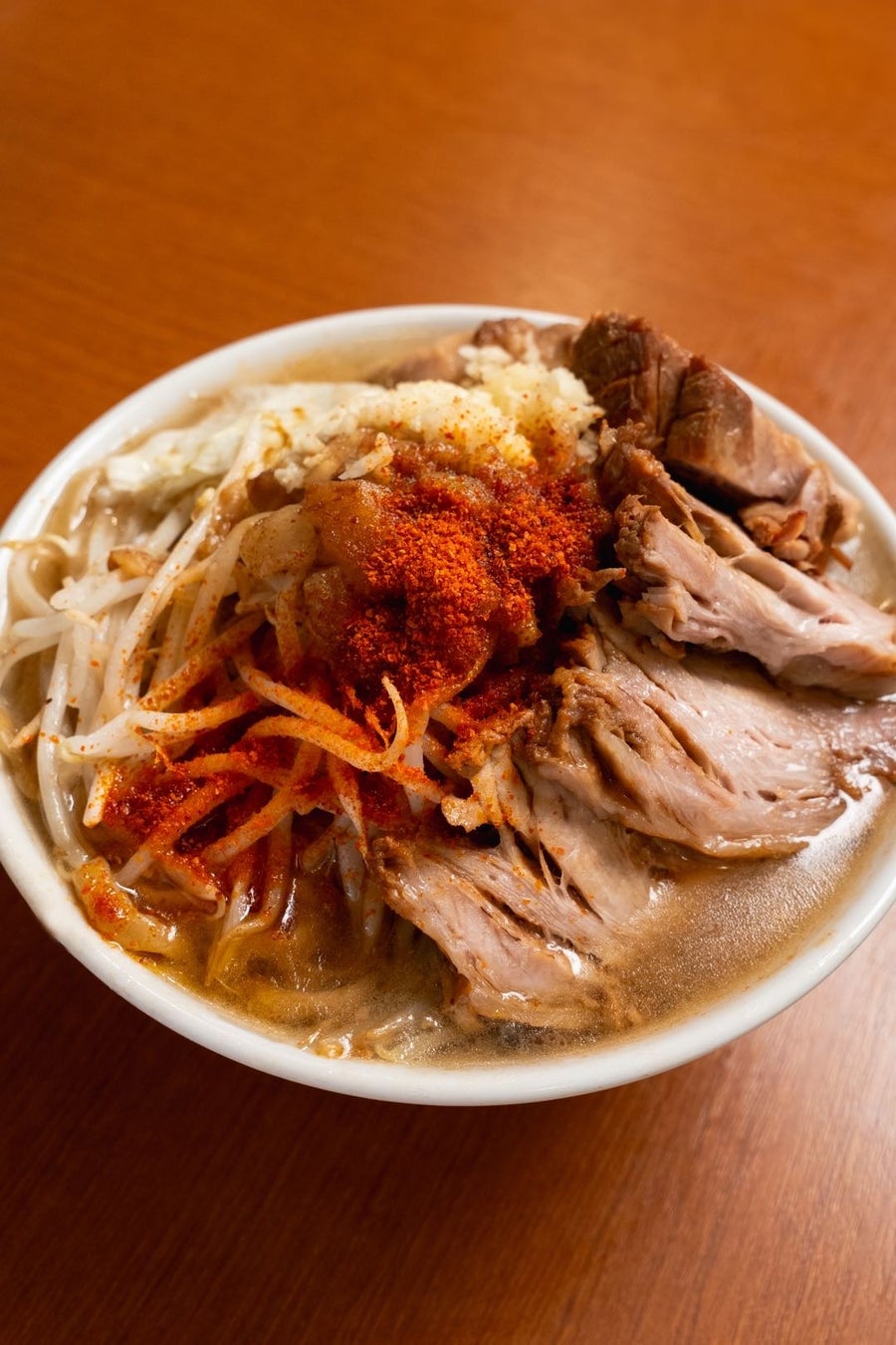 This bowl features extra pork (3 slices) for ¥250, with additional toppings like vegetables, back fat, garlic, cheese for ¥50, and black oolong tea for ¥200.