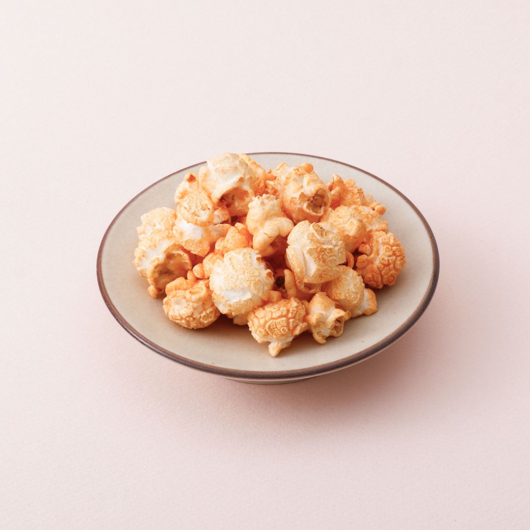 We have prepared a lineup of new products including the Thick Cut Mentaiko Cheese Potato Chips — ¥378 (tax included). In addition, there are popular items from last year such as the Nuri Pan Mentaiko Toast — ¥432 (tax included), Mentaiko Takana Spicy Rice Seasoning — ¥432 (tax included), and Mentaiko Takana — ¥432 (tax included). Other featured items include Mentaiko Dashi Chazuke — ¥432 (tax included), Rich Mentaiko Cream Risotto — ¥410 (tax included), and Spicy Mentaiko Monja — ¥518 (tax included). Snacks like Mentaiko Butter Popcorn — ¥378 (tax included), Mentaiko Potato Sticks — ¥378 (tax included), Yuzu Mentaiko Mayo Snack — ¥378 (tax included), and Mentaiko Cheese Okaki — ¥378 (tax included) are also available. Additionally, the collaboration commemorates the launch of freshly made Mentai Kiriko (Silk Box) 150g — ¥1,836 (tax included) at the Harajuku main store.