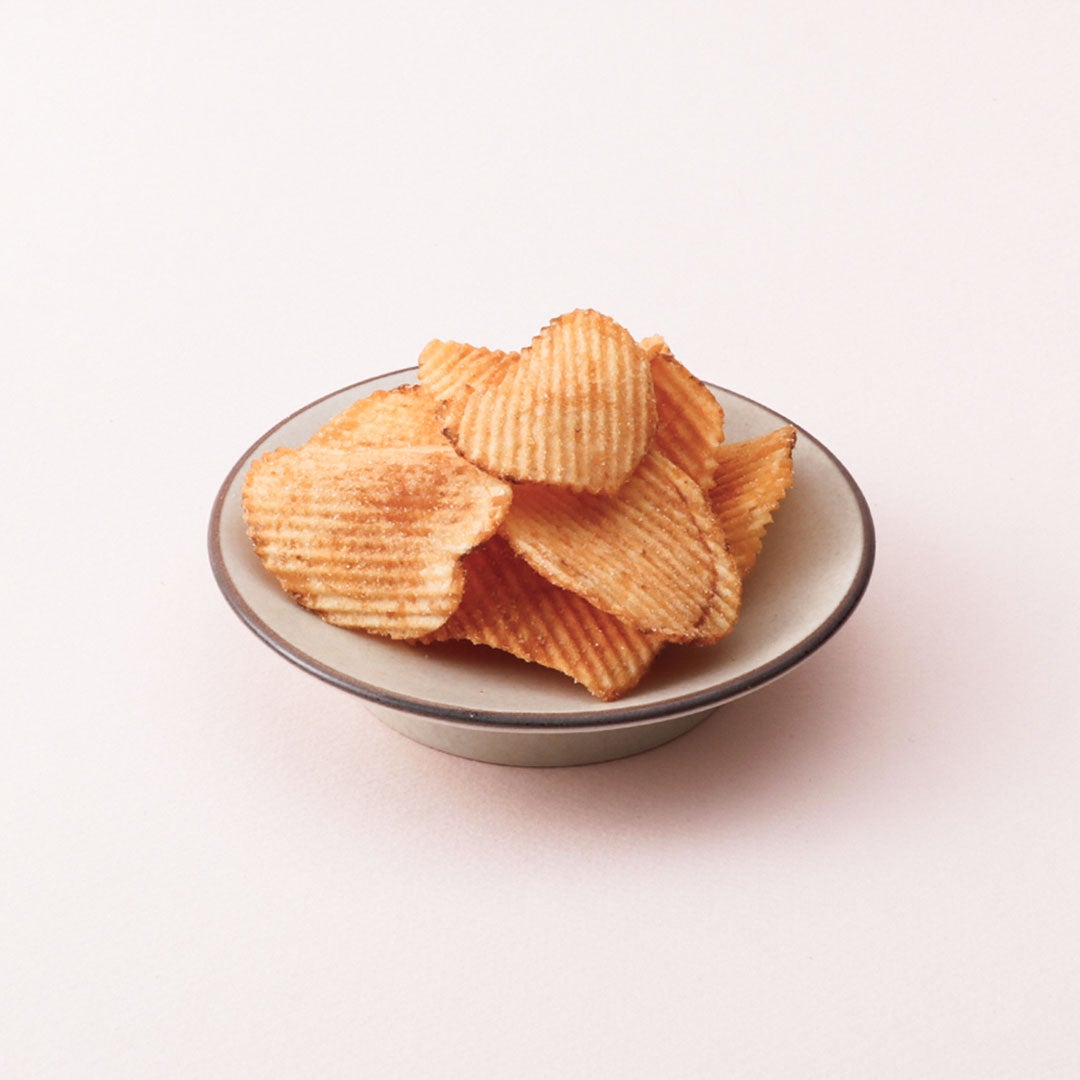 We have prepared a lineup of new products, including the Thick Cut Mentaiko Cheese Potato Chips for ¥378 (tax included). In addition to the new items like the Thick Cut Mentaiko Cheese Potato Chips and Mentaiko Mayo Ika Tempura for ¥486 (tax included), last year's popular offerings such as the Nuri Pan Mentaiko Toast for ¥432 (tax included) and Mentaiko Takana for ¥432 (tax included) are also available. Other menu items include Mentaiko Takana Spicy Rice Base for ¥432, Mentaiko Dashi Chazuke for ¥432, Rich Mentaiko Cream Risotto for ¥410, and Spicy Mentaiko Monja for ¥518. Snack options feature Mentaiko Butter Popcorn for ¥378, Mentaiko Potato Sticks for ¥378, Yuzu Mentaiko Mayo Snack for ¥378, Mentaiko Chips for ¥378, Yuzu Mentaiko Mayo Snack for ¥378, and Mentaiko Cheese Okaki for ¥378. Additionally, Mentaiko Mayo Ika Tempura is priced at ¥486, and Mentaiko Uzura at ¥540. Saku Saku Nori Tempura with Garlic Flavor costs ¥324. To commemorate this collaboration, the Harajuku main store offers freshly made Mentai Kiriko (Silk Box) 150g for ¥1,836 (tax included).