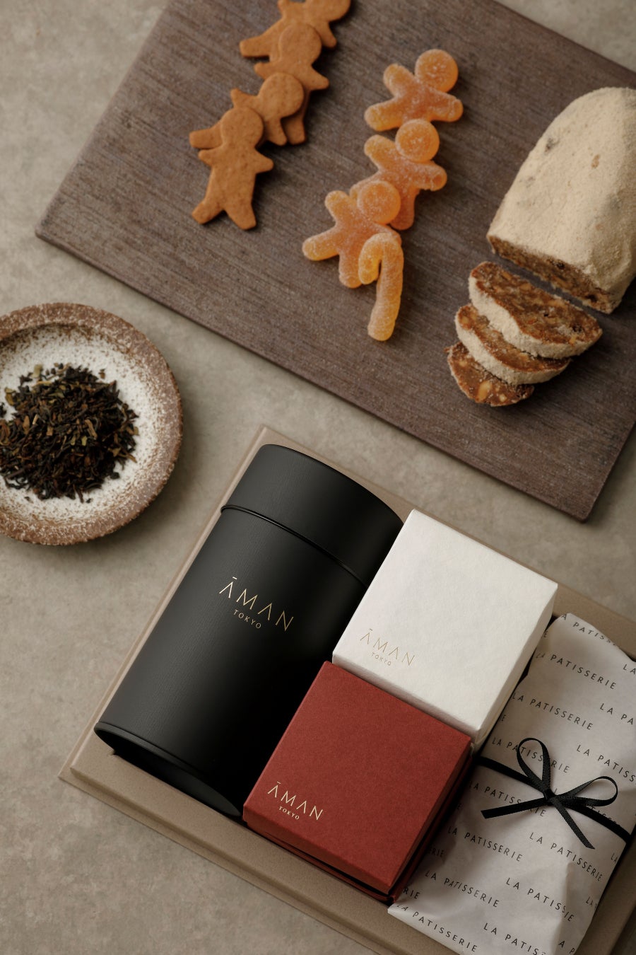 La Patisserie by Aman Tokyo offers a special 'Christmas Gift Box 2026' celebrating the season. It includes festive treats like Stollen, KOBAKO's Gingerbread Man Cookies, Pate de Fruits, and Ronnefeldt's Darjeeling Earl Grey Tea in a beautifully curated box. Perfect for holiday gifting or a personal indulgence. Available from Nov 16 to Dec 25. Price: ¥8,700 (tax included)