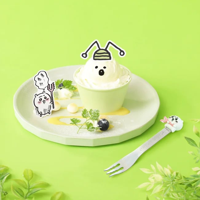 Insect (green) subjugation ice dessert — ¥1,100 (tax included). Gichi-Gichi-Gichi—the green insect appears! Defeat it with a spear-style fork. Under the vanilla ice representing the insect are custard and mango dice. Picks are available to take home. Spear-style forks are sold at the official EC and Chiikawa restaurant goods shop.