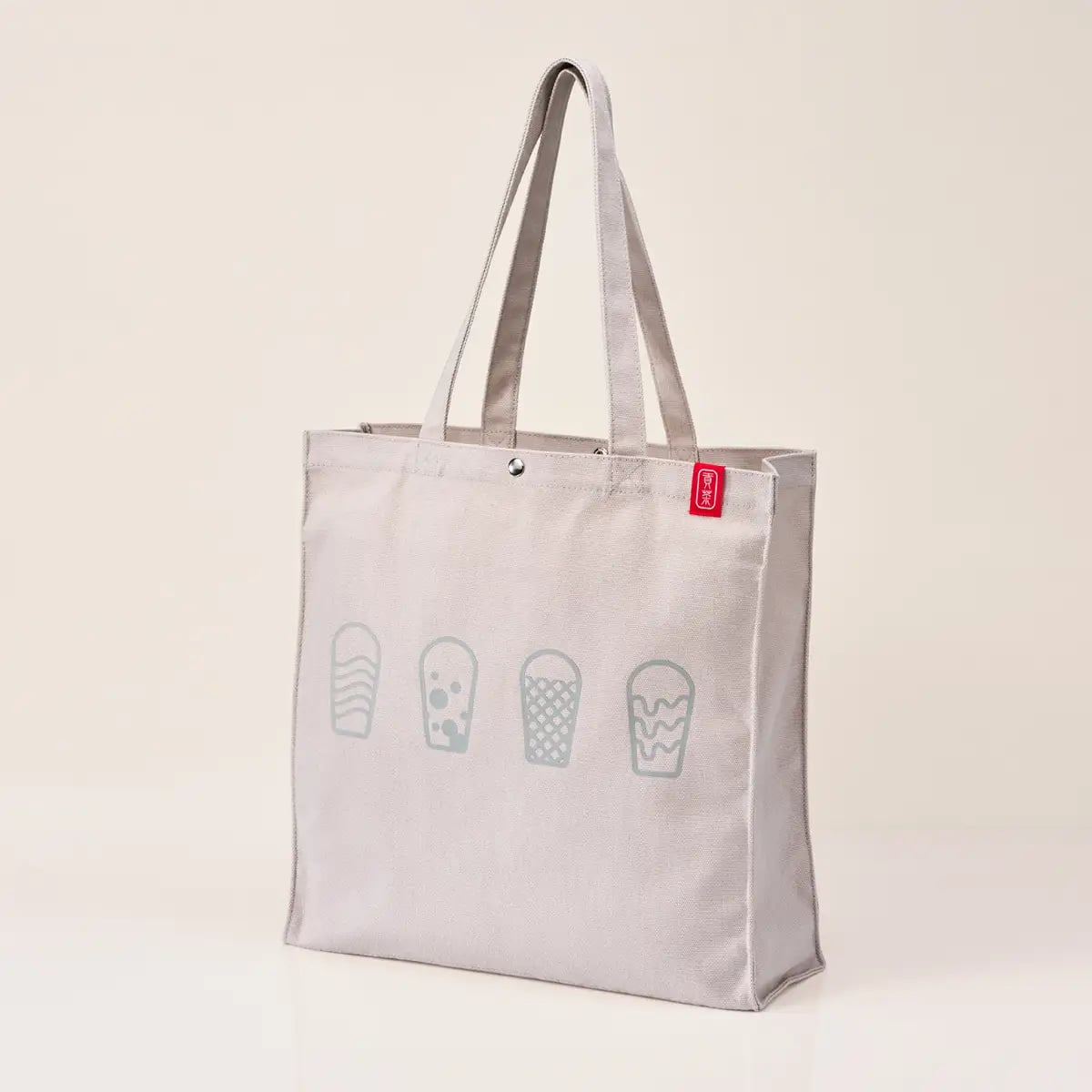 Original Tote Bag. Simple, versatile design that goes with any outfit. Large enough for A4, with sturdy fabric, a divider, inner pocket, and a buttoned opening for ease of use. Size: 39 cm high × 37 cm wide × 12 cm gusset. ¥7,500 (tax included).