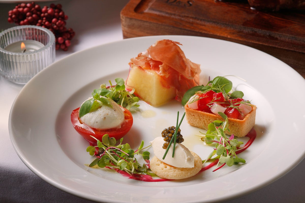 Christmas Special Antipasto with 4 kinds: aged prosciutto and ripe melon, buffalo mozzarella and tomato caprese, caviar and sour cream blini, marinated salmon and scallops in beets. A festive appetizer perfect for the start of Christmas, featuring a colorful assortment of flavors.