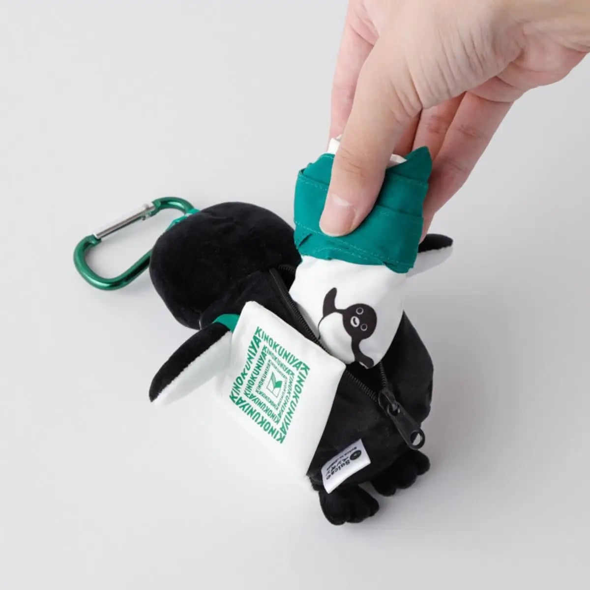 When you open the zipper on the back, an eco bag featuring the KINOKUNIYA logo and the Suica penguin appears from inside.