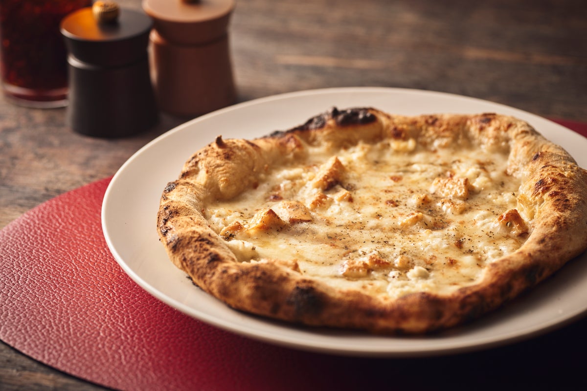 The Quattro Formaggi Pizza, meaning 'four cheeses,' actually uses six types of cheese, each with unique richness, saltiness, and aroma, creating a layered flavor profile. Topped with a honey-based sauce combining oregano, honey, and olive oil, it offers a deep, mellow taste with a balance of sweetness and saltiness, priced at ¥4,536 (tax included).