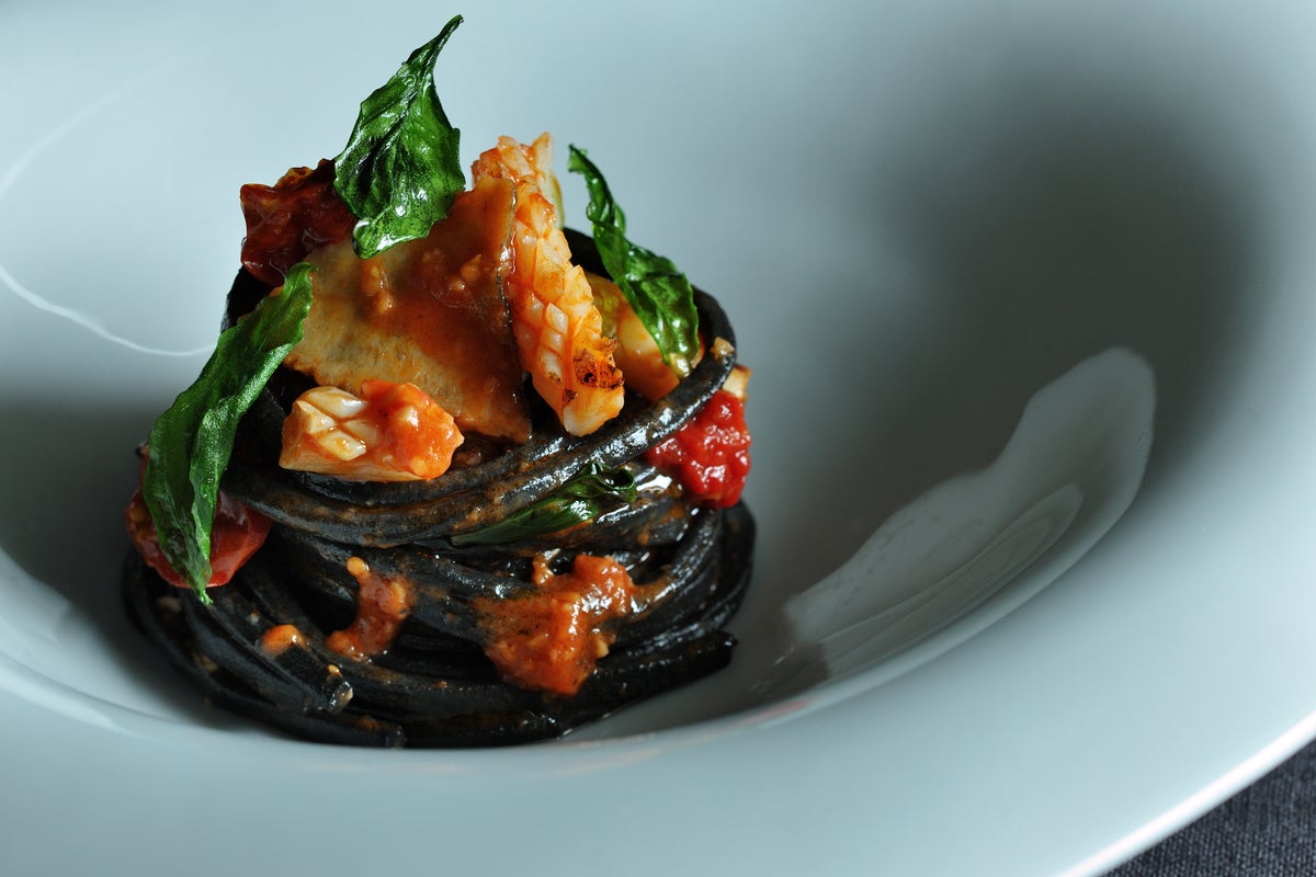 Cuttlefish ink tagliatelle with Aori squid and luminescent shellfish in tomato sauce.