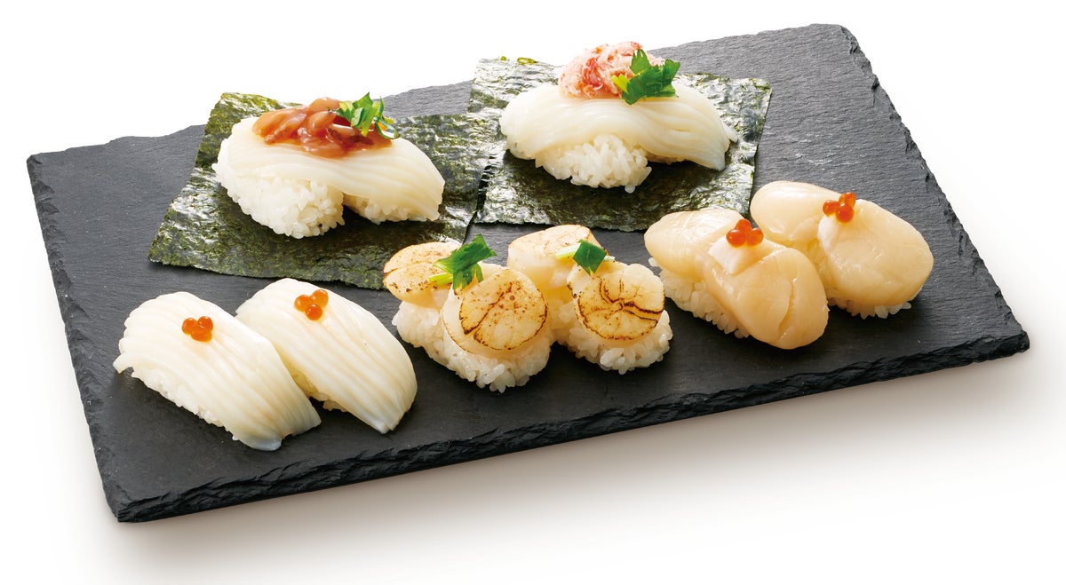 Hand-rolled sushi with salted cod roe on the top left; squid sushi with crab on the top right; squid nigiri on the bottom left; seared scallop nigiri in the center bottom; scallop nigiri on the bottom right.